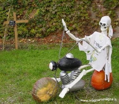 Bellissima scultura di Halloween: hanno creato in giardino uno scheletro che va in motocicletta, realizzato con pezzi di legno e zucche. Paurosamente bella.